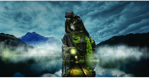 A stone statue covered in luminescent green moss stands in a misty lake surrounded by mountains under a stormy sky.