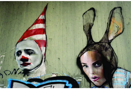 Street art canvas showing two stylised faces on weathered green background: a clown in red and white striped hat on the left, and a figure with black rabbit ears on the right.
